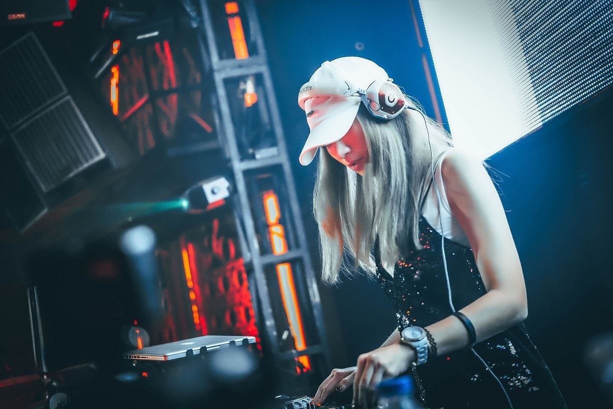 Music producer working at a mixing desk with glowing lights