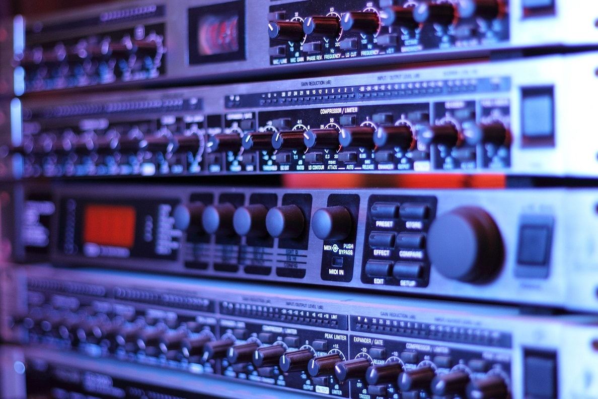 Rack of studio audio equipment with glowing level meters