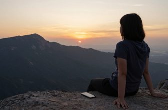 person contemplating sunset with smartphone set aside