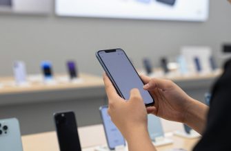 Person considering smartphone purchase in store