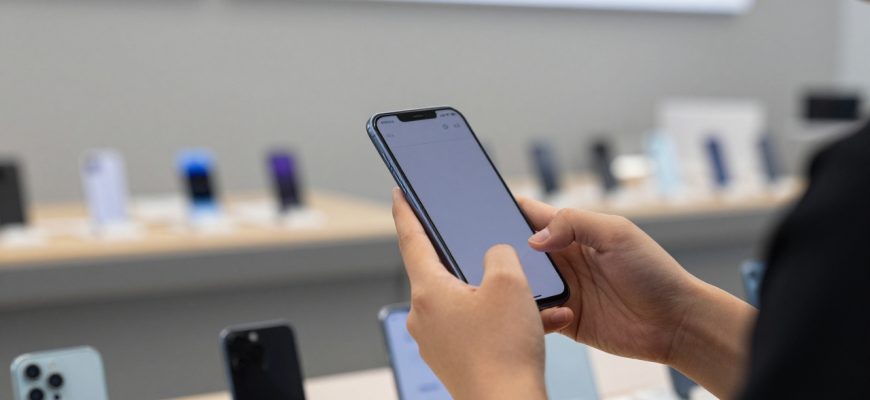 Person considering smartphone purchase in store