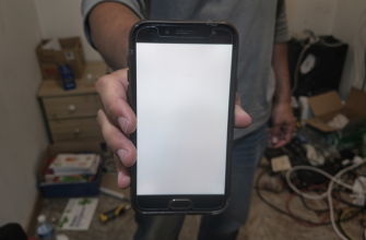 Person holding a budget smartphone with a dim screen